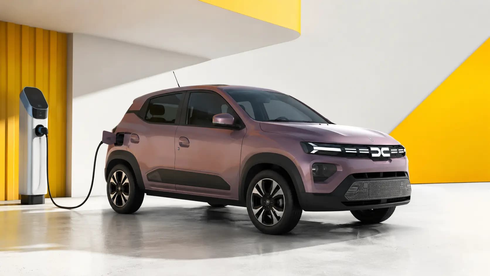 Modelo Dacia eletrificado junto a um posto de carregamento